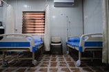white split type air conditioner over white and blue hospital bed