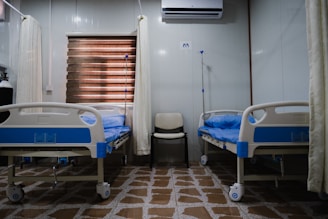 white split type air conditioner over white and blue hospital bed