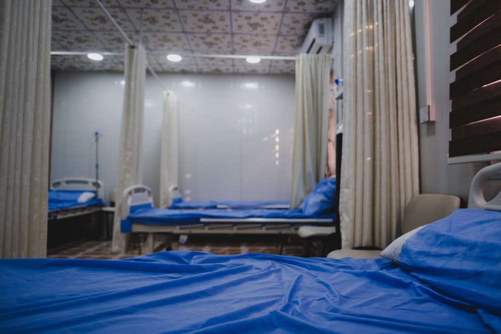 blue bed linen near white window curtain