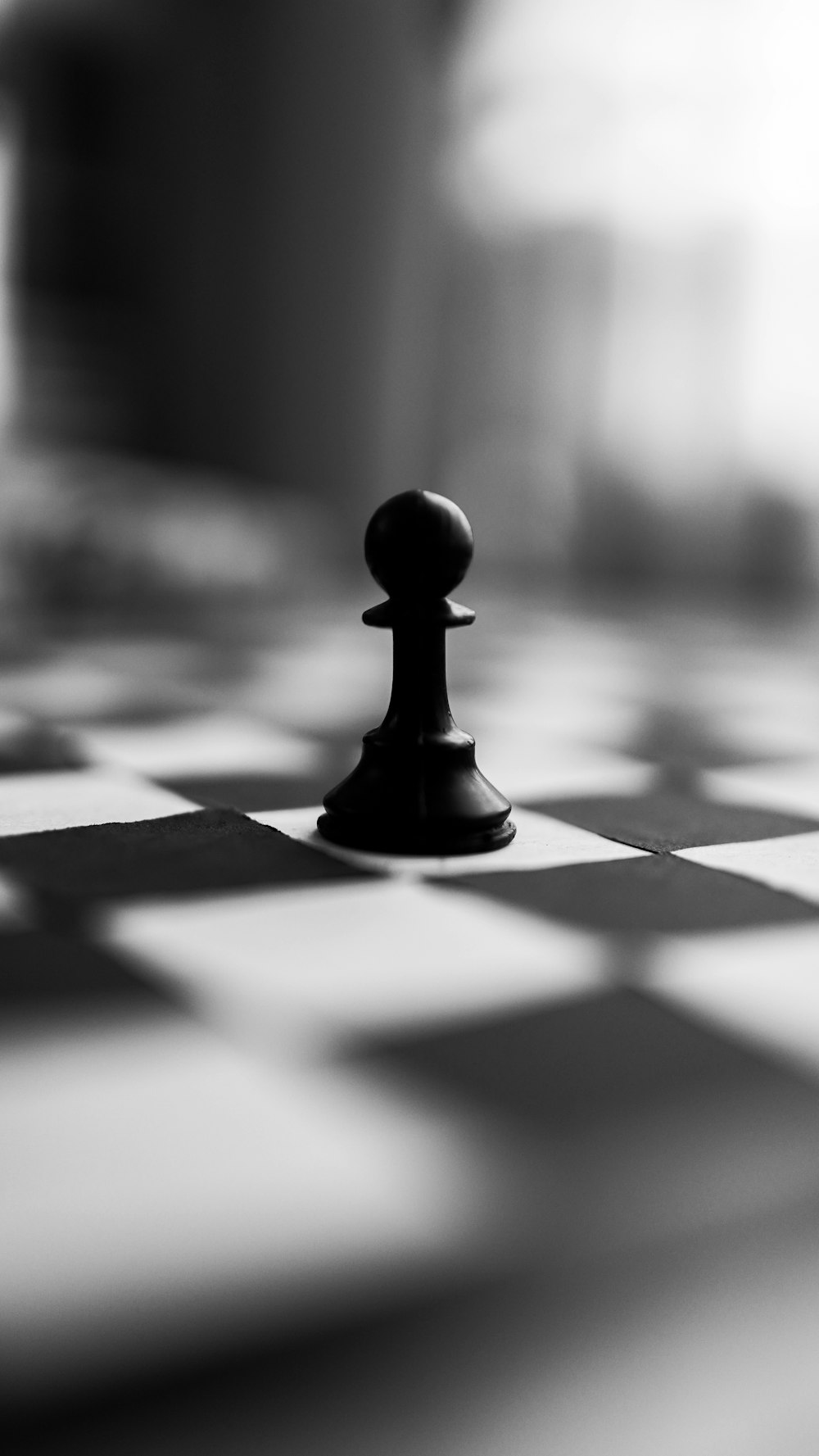 pieza de ajedrez negra sobre tela a cuadros blanca y negra