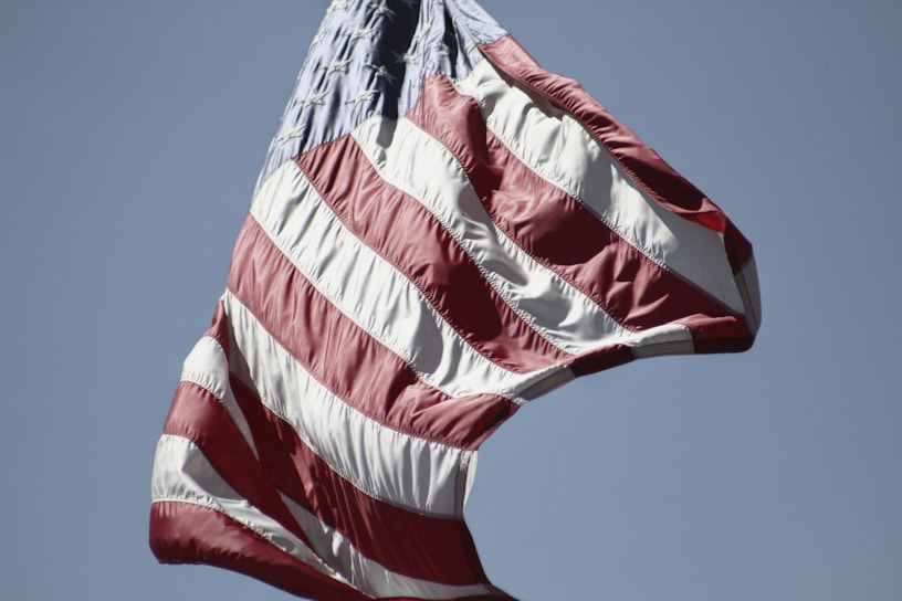 A close-up of a vibrant American flag waving proudly against a clear blue sky.