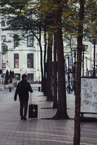 man in black jacket walking on sidewalk during daytime