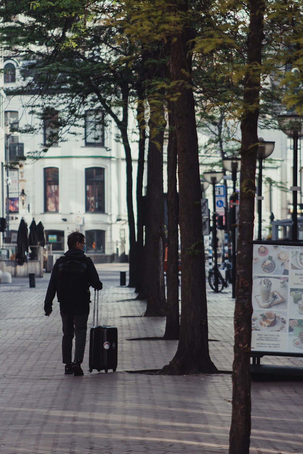 Mann in schwarzer Jacke tagsüber auf dem Bürgersteig
