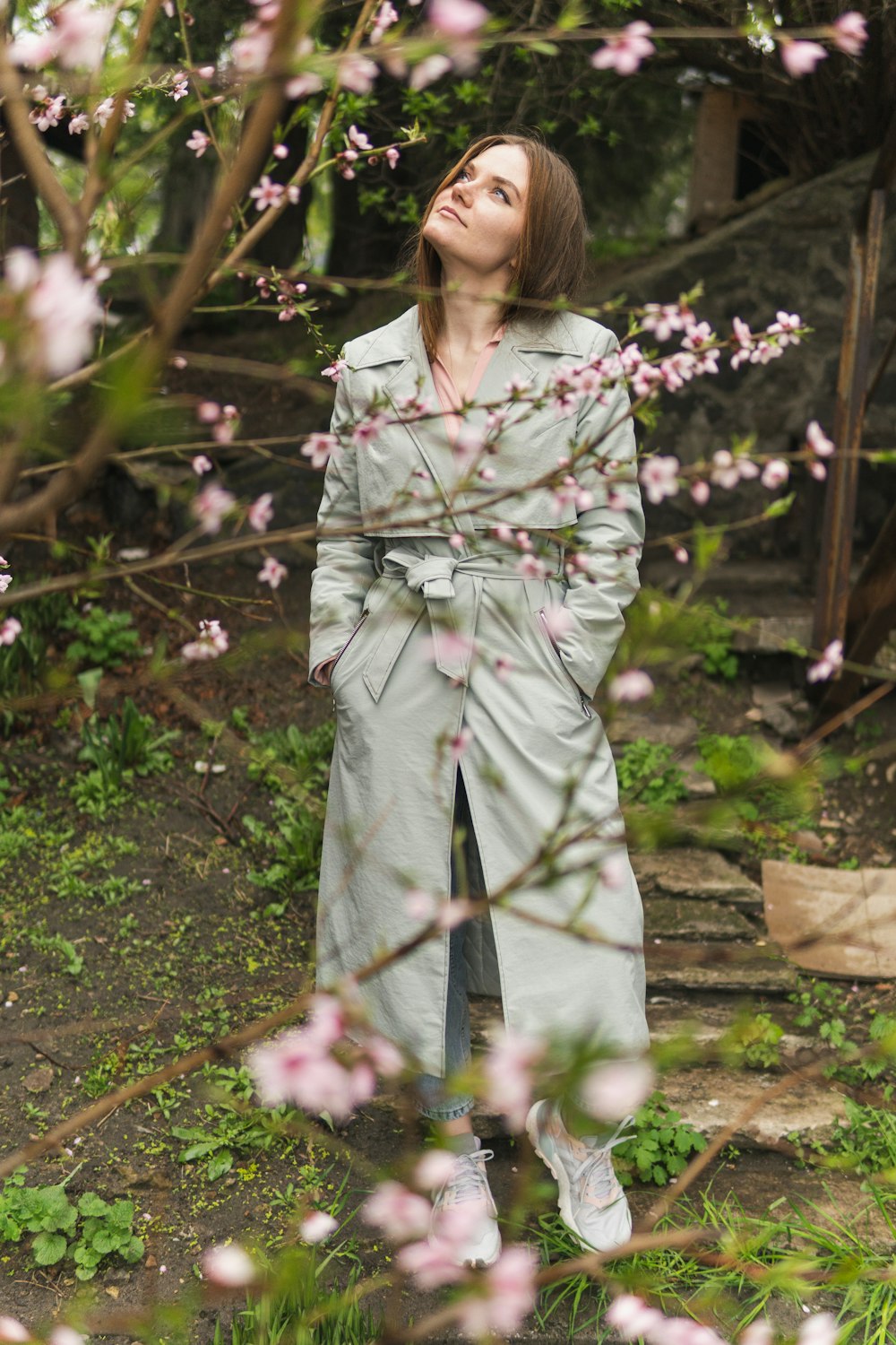woman in white long sleeve dress standing near green plants