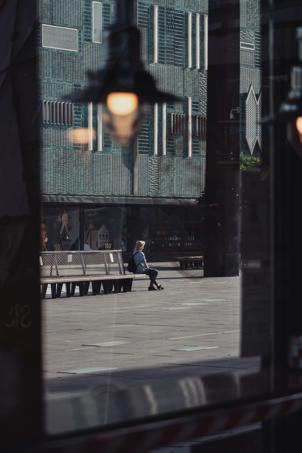 man in black jacket and black pants sitting on bench