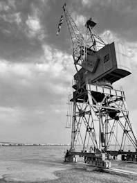 Technicians repairing a jib crane at a waterfront facility.