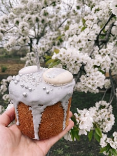 A happy customer holding a beautifully decorated cake at home.