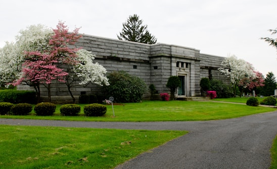 A serene funeral home entrance with white walls and dark orange accents, reflecting warmth and respect.