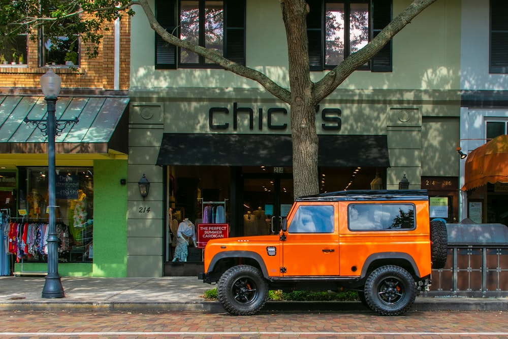 orange jeep wrangler parked near building during daytime