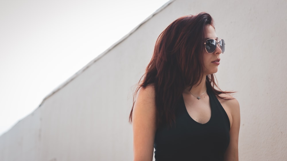 Femme en débardeur noir portant des lunettes de soleil noires