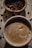 Close-up of a steaming cup of black coffee on a wooden table.