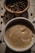 A close-up shot of a steaming cup of coffee beside a plate of succulent shrimp on a rustic wooden table.