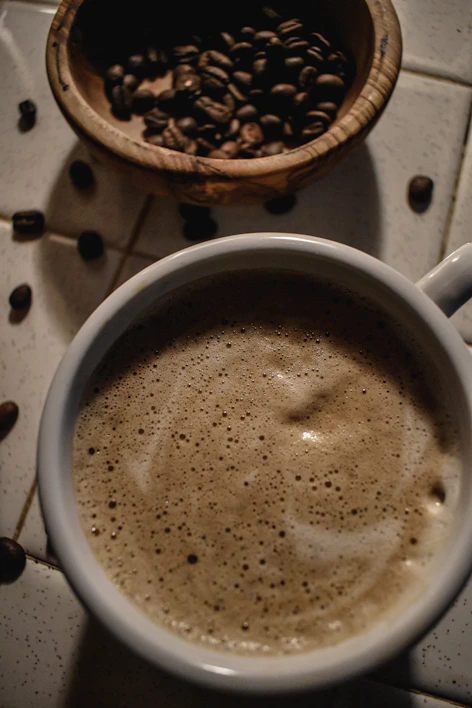 Close-up of a steaming cup of freshly ground coffee with warm morning light.
