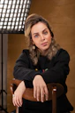 woman in black jacket sitting on brown wooden chair