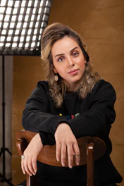 woman in black jacket sitting on brown wooden chair