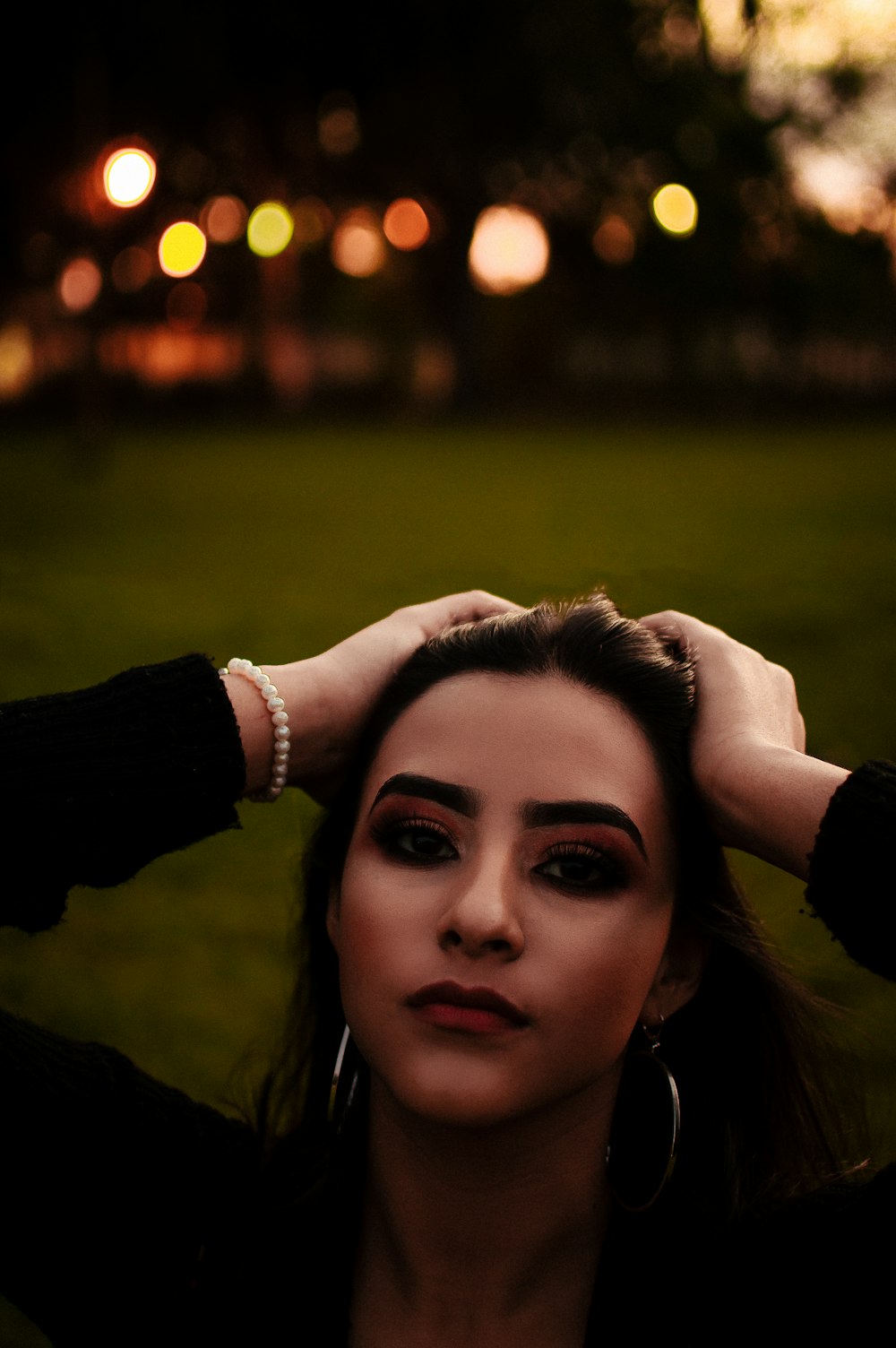 woman in black long sleeve shirt holding her hair