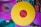 Two vinyl records are displayed, one in vibrant yellow with a red center and the other in vivid pink. The records rest atop a collection of album covers featuring various artistic designs and text, including the words 'Enter the Wu-Tang'.