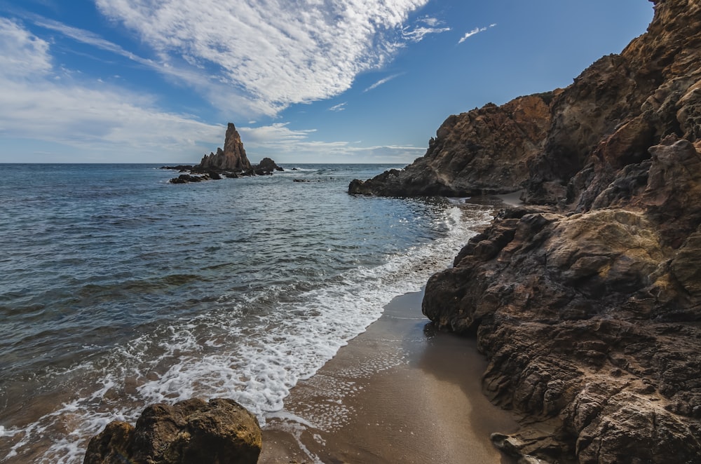 brown rock formation on sea shore during daytime