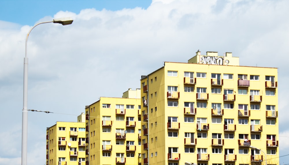 Bâtiment en béton jaune et brun sous le ciel bleu pendant la journée