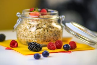Close-up of a jar filled with creamy overnight oats topped with fresh berries and a sprinkle of nuts, softly lit by morning light.