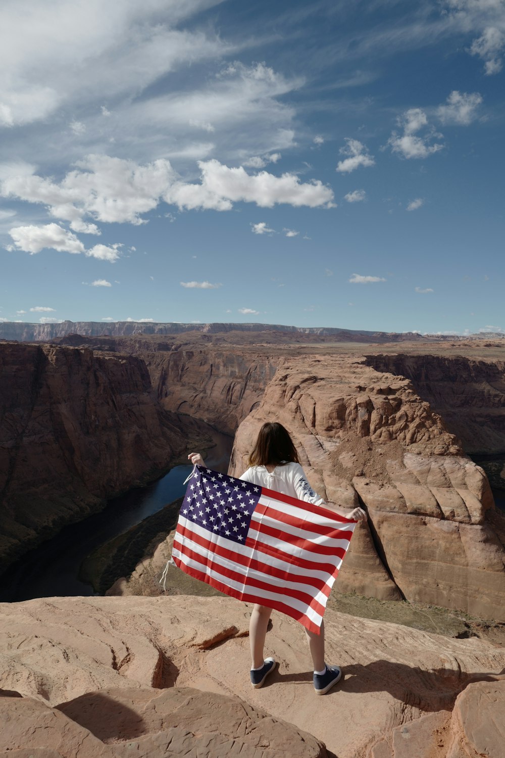 us a flag on brown rock formation under blue sky during daytime