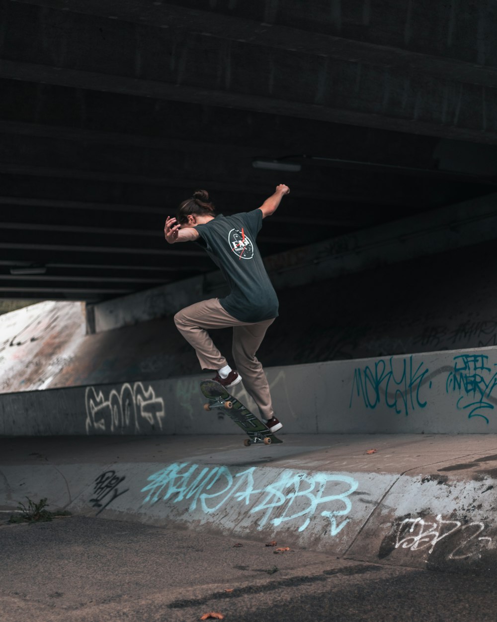 man in black t-shirt and black pants doing skateboard stunts