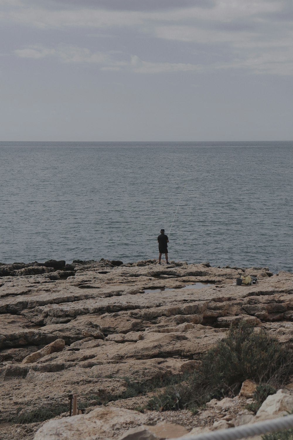 person standing on brown rock near body of water during daytime