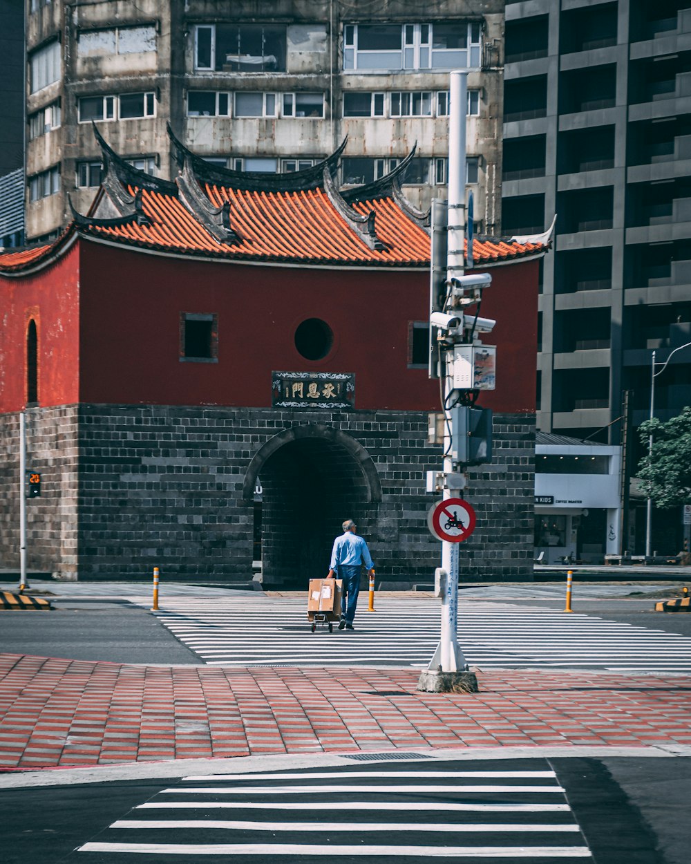 man in black jacket walking on sidewalk during daytime