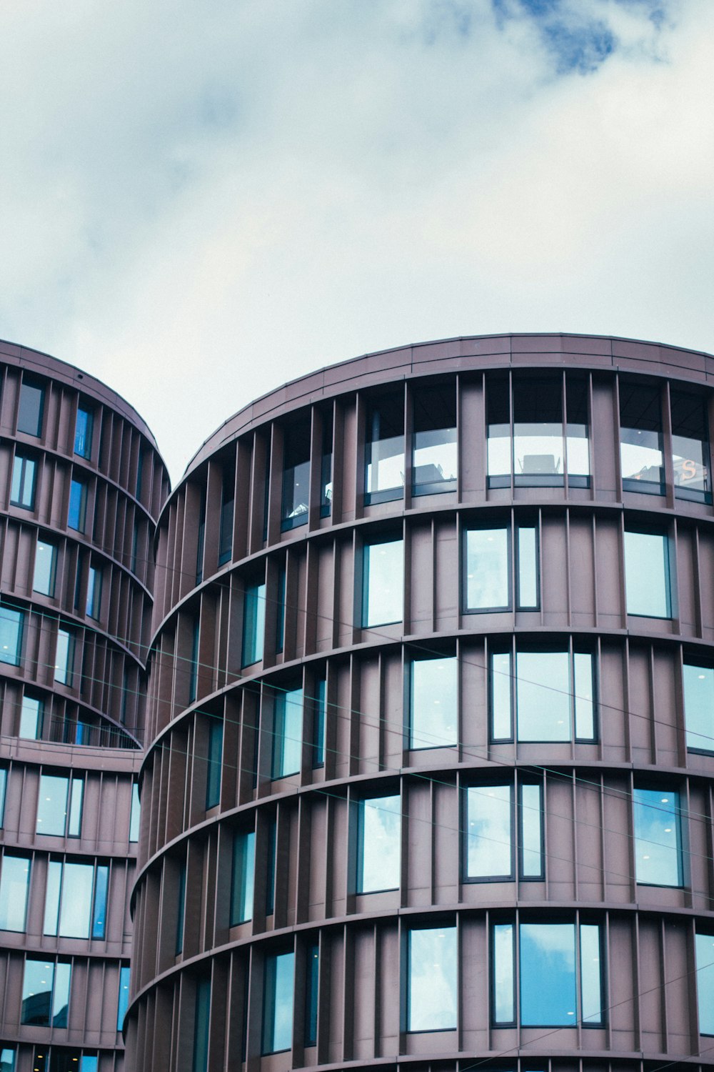 Graues Betongebäude unter weißen Wolken tagsüber