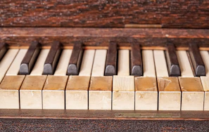 Close-up of piano keys showing signs of age and use, telling tales of many melodies played.