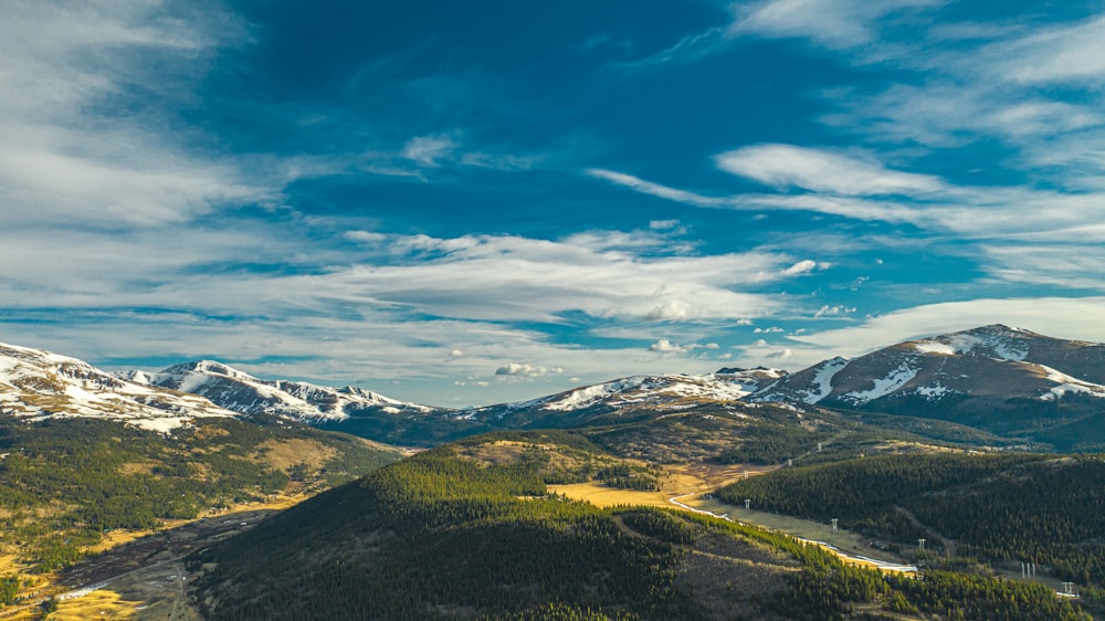 grüne und braune Berge unter blauem Himmel und weißen Wolken tagsüber