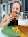 Man enjoying a meal at a restaurant, looking relaxed and satisfied.
