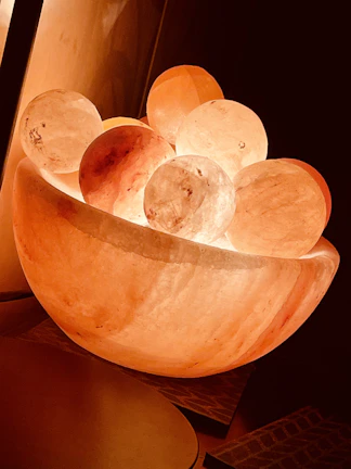 Softly lit sound bath session with crystal singing bowls glowing warmly.