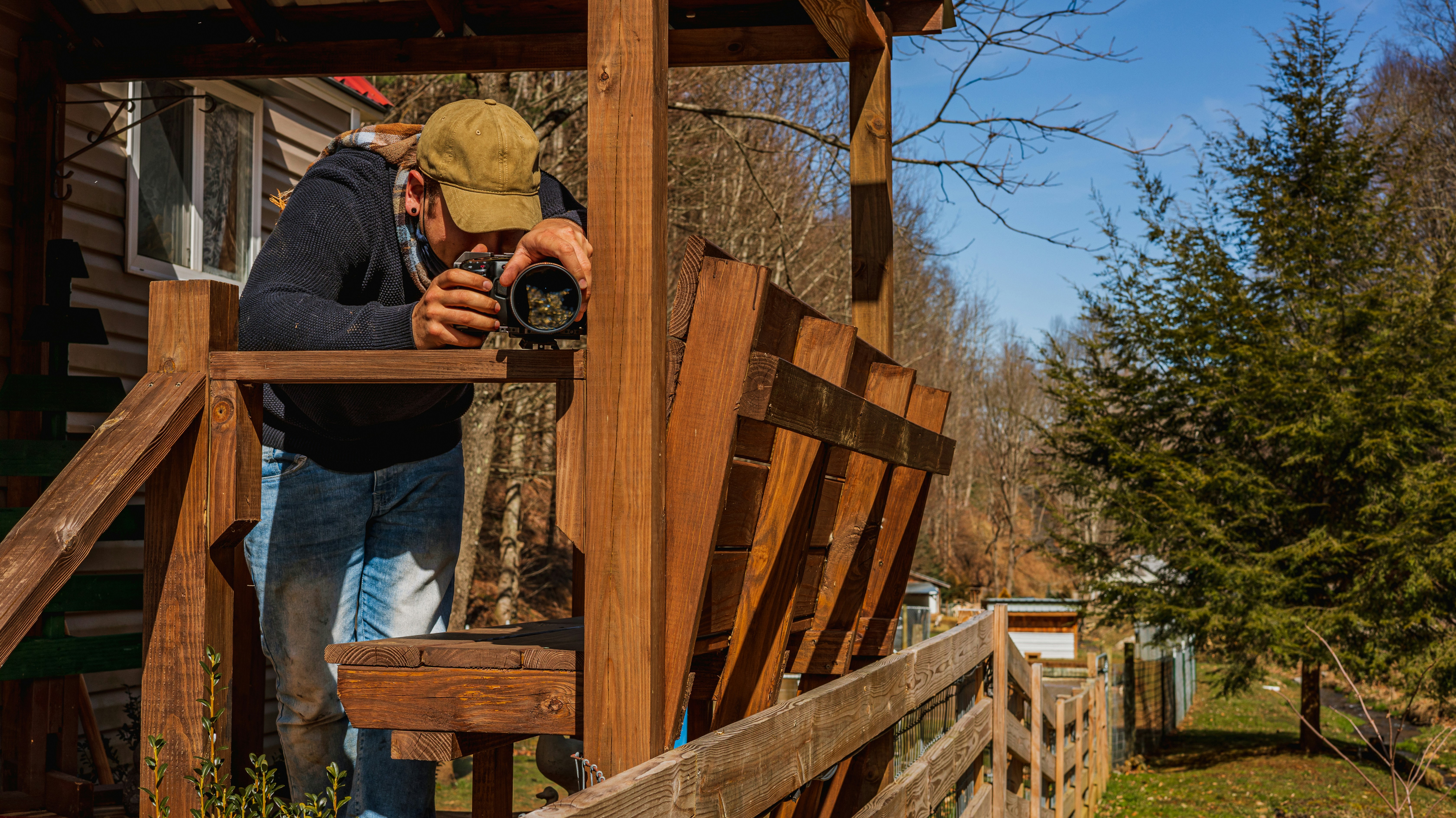 man in blue denim jacket and blue denim jeans holding black dslr camera