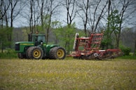 A sturdy tractor parked beside a field ready for plowing at dawn.