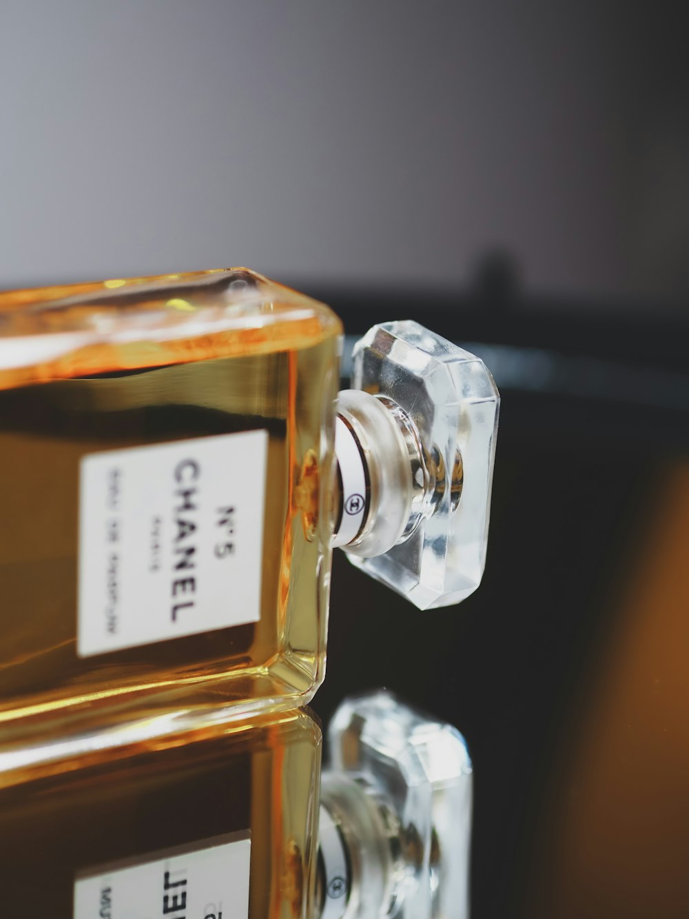 clear glass perfume bottle on black table