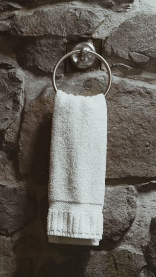 A stylish bathroom featuring an elegant towel ring and hooks.