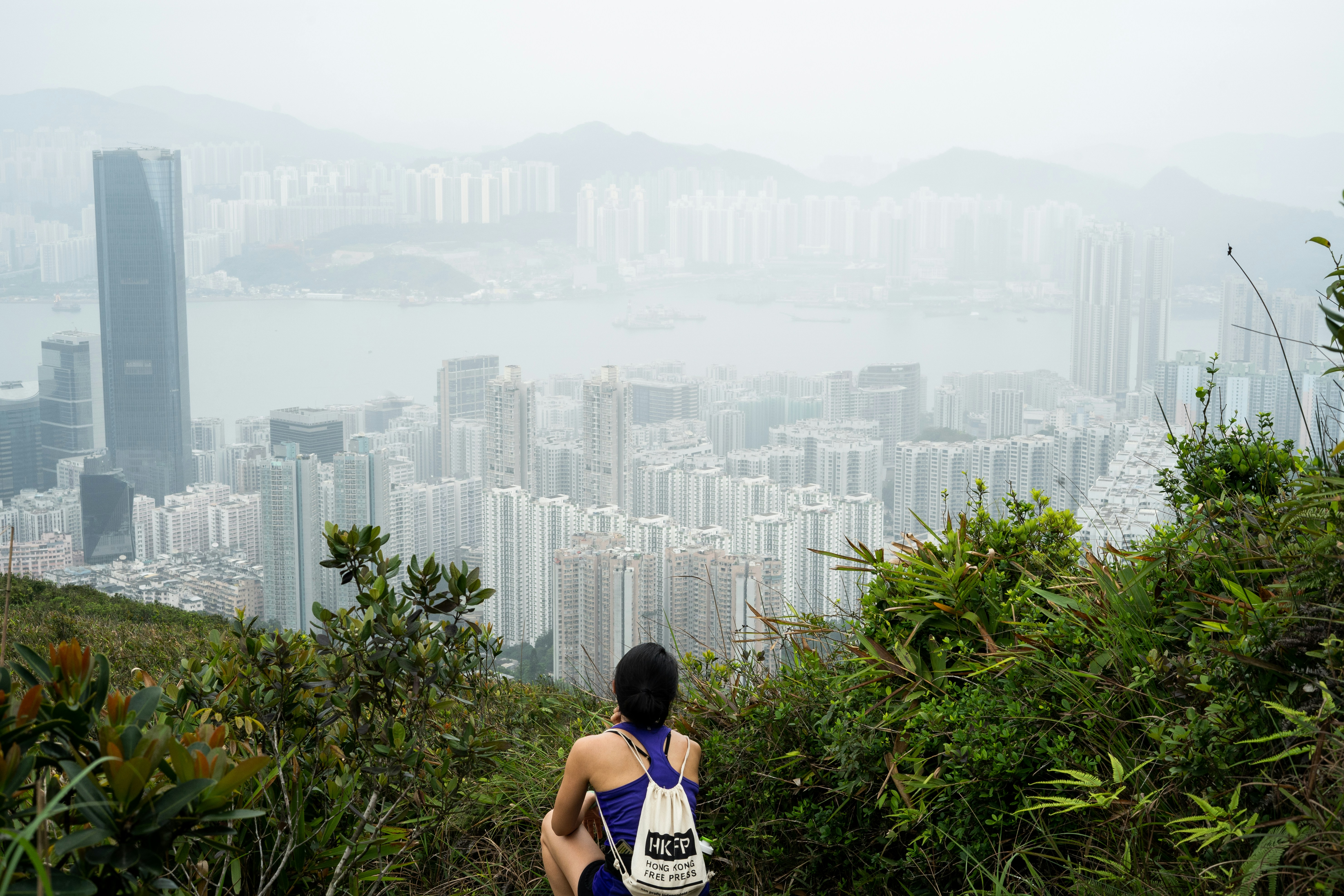 Woman in blue and white tank top standing near green plants during ...
