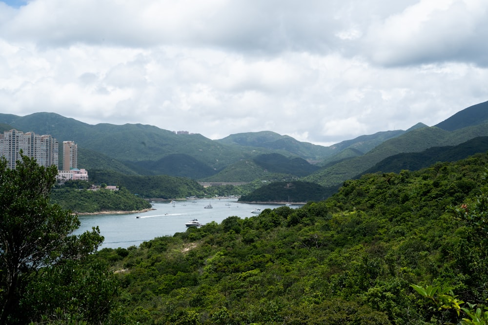 green mountains near body of water under cloudy sky during daytime