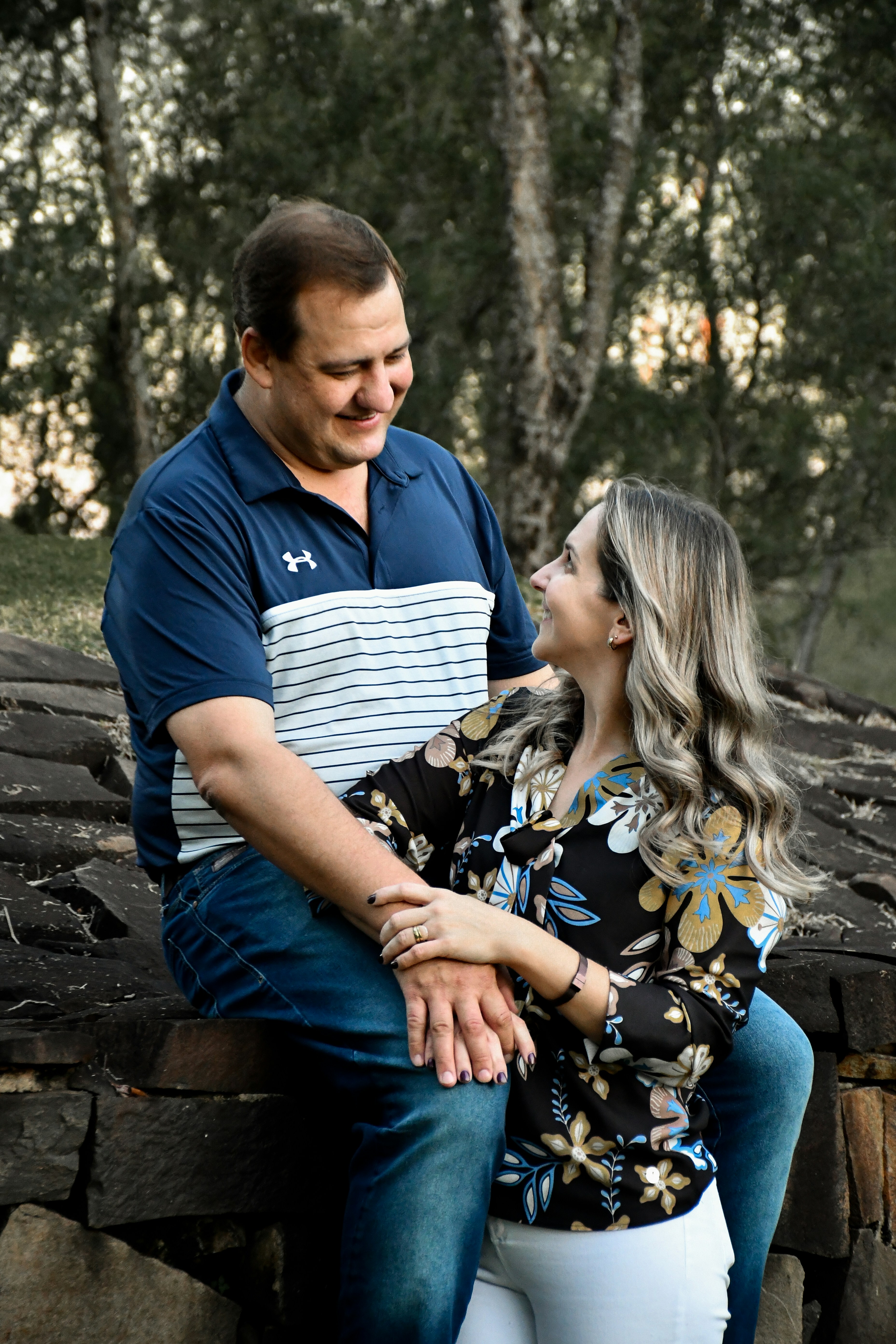 man in blue polo shirt sitting beside woman in black and white floral dress