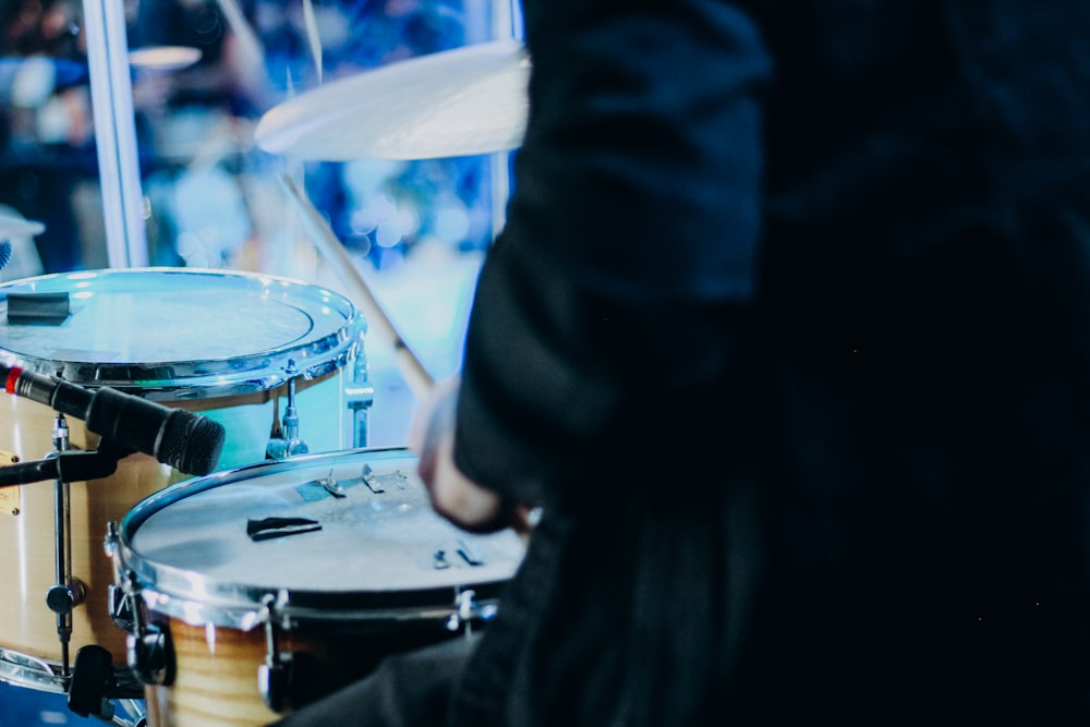 person in black jacket playing drum