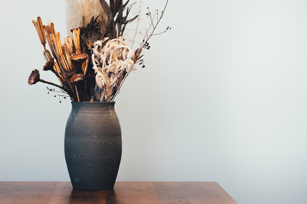 brown and white ceramic vase on brown wooden table