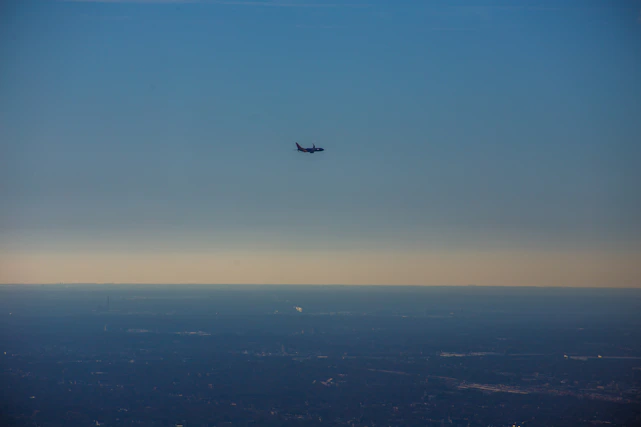 A sleek, modern aircraft soaring above a city skyline at dusk, symbolizing advanced air mobility.