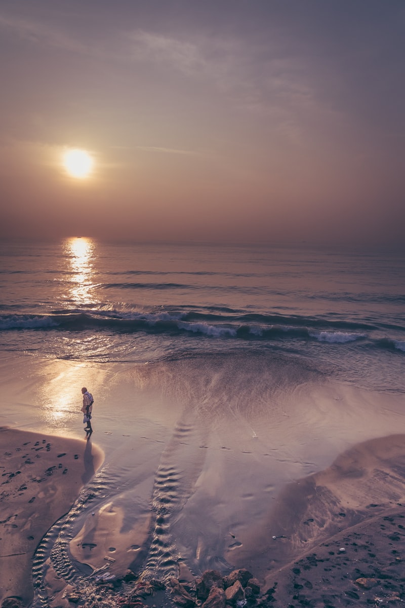 Person walking along coastal path at sunrise