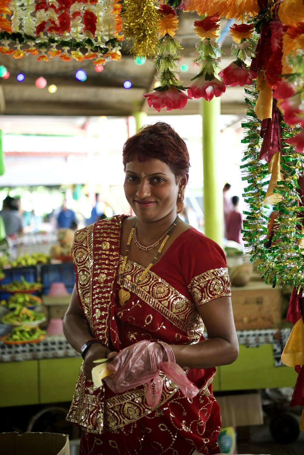 woman in red and brown sari smiling