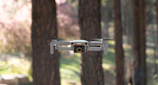 A dramatic shot of a drone flying over a wooded area, capturing footage for a first responder exercise.