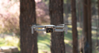 The compact DJI Avata drone flying through a lush forest trail.