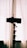 A silhouette of a camera on a tripod is positioned in front of a curtain, with soft natural light filtering through, creating a minimalistic and artistic effect.