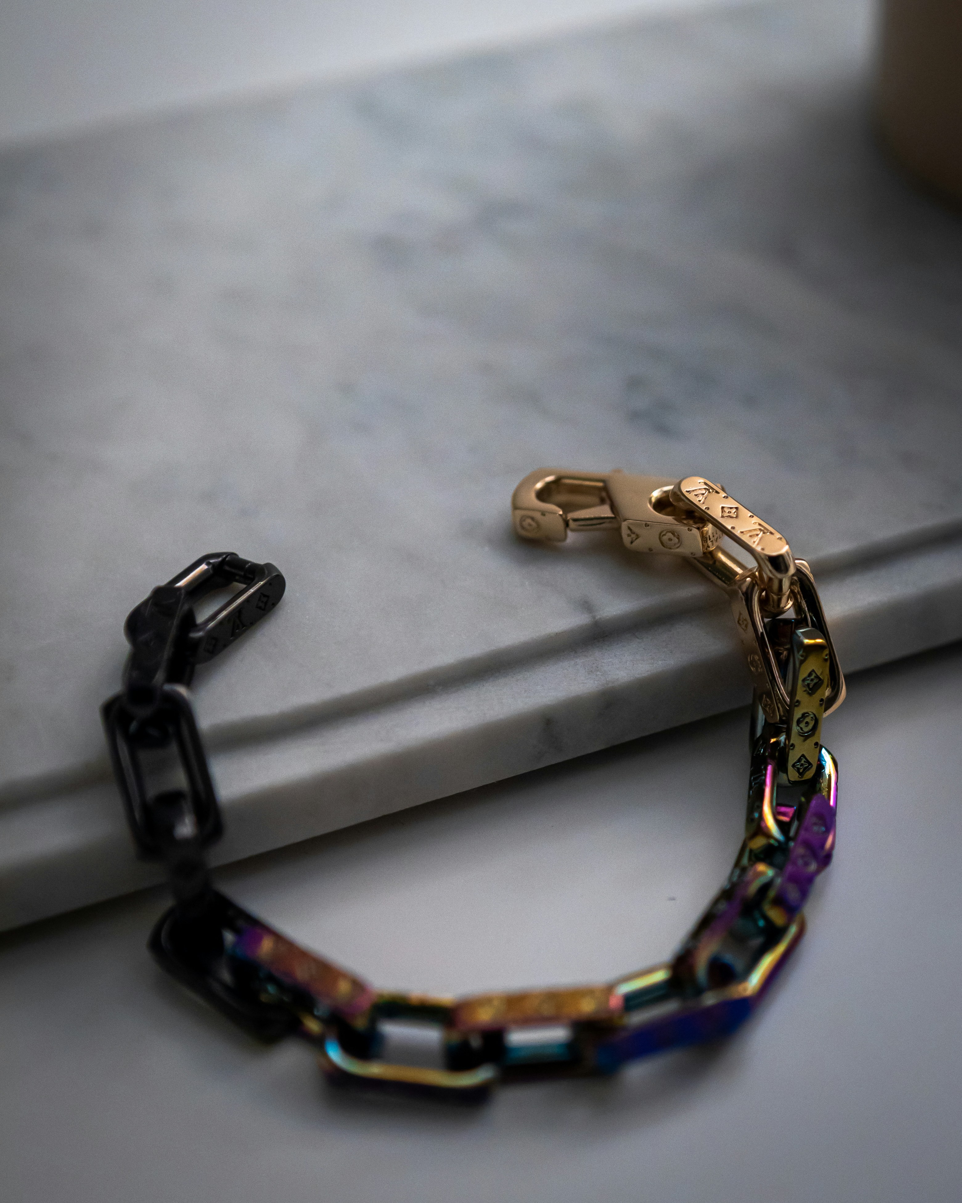 Gold and amber crystal bracelet with multiple gemstones on white marble surface