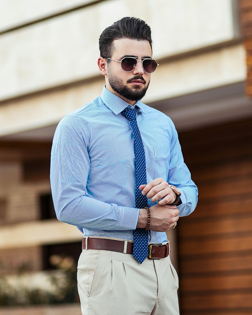 Homme en chemise bleue portant des lunettes de soleil noires